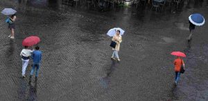 Passanti con ombrelli durante un temporale a Roma (Immagine di archivio)