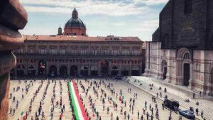 La bandiera tricolore srotolata in Piazza Maggiore a Bologna (Immagine di repertorio)