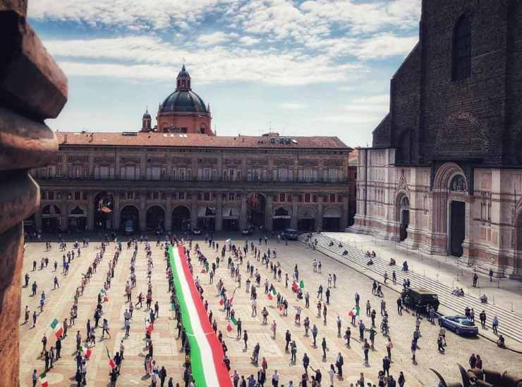 La bandiera tricolore srotolata in Piazza Maggiore a Bologna (Immagine di repertorio)