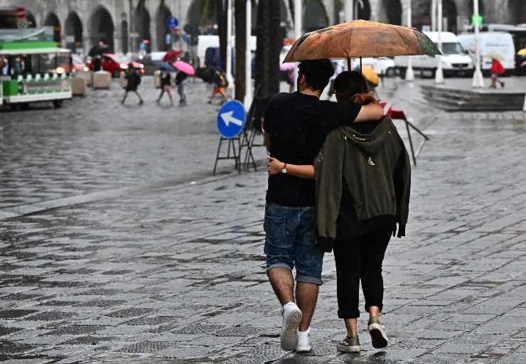 Turisti che si ripararano dalla pioggia a Genova (Immagine di repertorio)