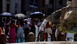 Turisti a Piazza Navona in cerca di riparo dal caldo