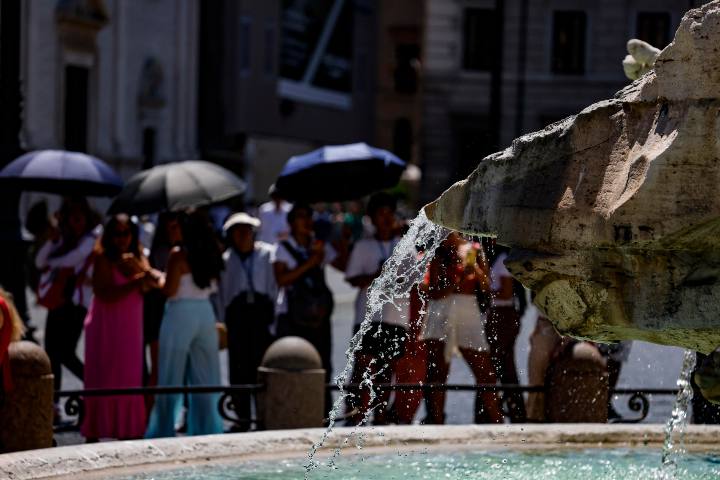 Turisti a Piazza Navona in cerca di riparo dal caldo