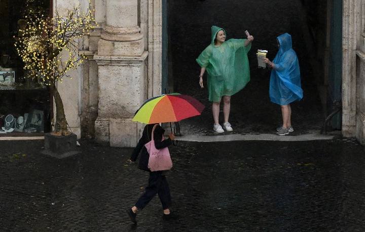 Passanti con ombrelli durante un temporale a Roma (Immagine di repertorio)