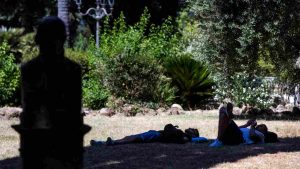 Persone si rinfrescano all'ombra a Villa Borghese, Roma