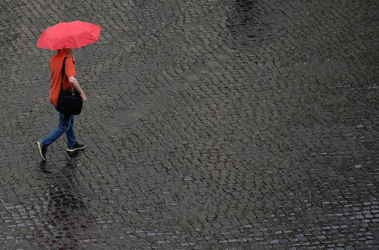 Passanti con ombrelli durante un temporale a Roma (Immagine di repertorio)