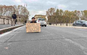 Un manifestante di Ultima Generazione durante il blitz sui ponti del centro di Roma