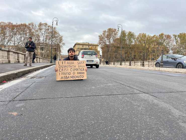 Un manifestante di Ultima Generazione durante il blitz sui ponti del centro di Roma