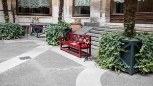 La panchina rossa nel cortile di Palazzo Montecitorio con il numero del centro antiviolenza e antistalking 1522 (Foto dal profilo X della Camera dei Deputati)