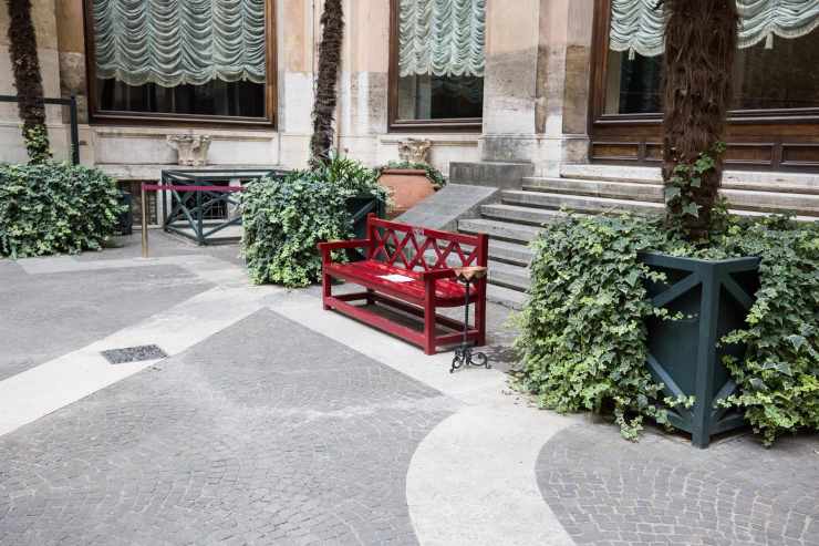 La panchina rossa nel cortile di Palazzo Montecitorio con il numero del centro antiviolenza e antistalking 1522 (Foto dal profilo X della Camera dei Deputati)